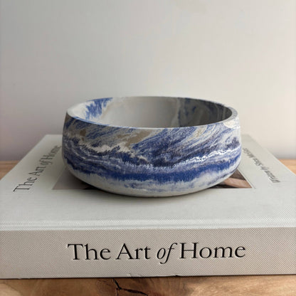 Marble-patterned ceramic bowl on a book titled 'The Art of Home'.