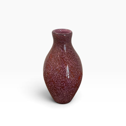 Small pink, spotted glass vessel with narrow neck.